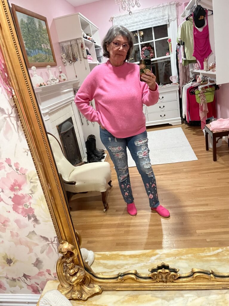 I am wearing holey jeans with pink floral patches and pink merino wool sweater