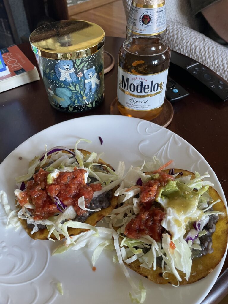 2 bean tostadas and a bottle of Modelo beer